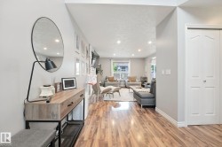Wood-finish flooring throughout, recessed lighting, white trim, and a white bi-fold door - 