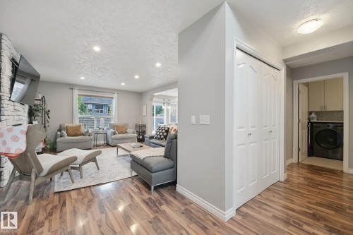 Wood-finish flooring throughout, recessed lighting, and a white painted brick fireplace surround - 324 Ascott Crescent, Sherwood Park, AB 