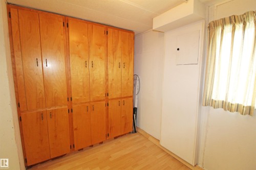 Built-in wood cabinetry providing extensive storage, wood-finish flooring, and a window with natural light - #16 4202 45 St, Wetaskiwin, AB 
