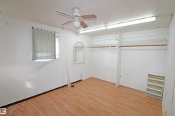 Wood-finish flooring, ceiling fan, built-in closet organization, and window with blinds - 