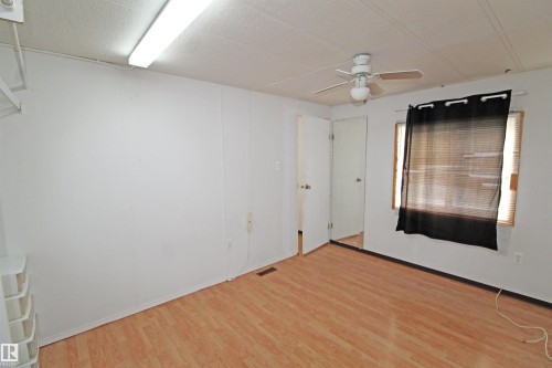 Wood-finish flooring, white walls, and a ceiling fan with light fixture - #16 4202 45 St, Wetaskiwin, AB 