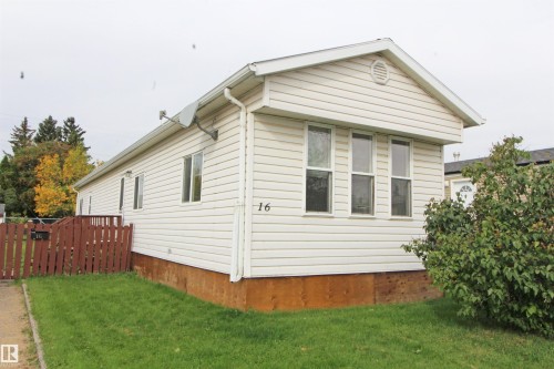 White horizontal siding with a contrasting brown fence and natural green landscaping - #16 4202 45 St, Wetaskiwin, AB 