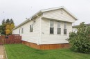 White horizontal siding with a contrasting brown fence and natural green landscaping - #16 4202 45 St, Wetaskiwin, AB 