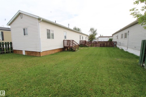 Expansive green lawn with a wood fence. - #16 4202 45 St, Wetaskiwin, AB 
