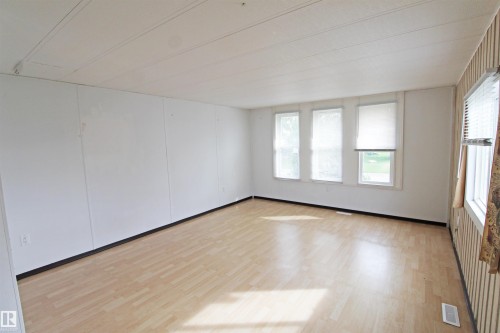 Light wood-finish flooring with white panel walls - #16 4202 45 St, Wetaskiwin, AB 