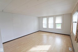 Light wood-finish flooring with white panel walls - 