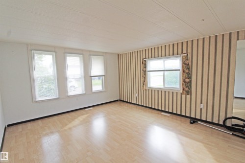 Light wood-finish flooring with multiple windows providing natural illumination - #16 4202 45 St, Wetaskiwin, AB 