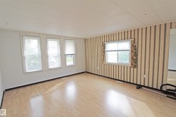 Light wood-finish flooring with multiple windows providing natural illumination - 