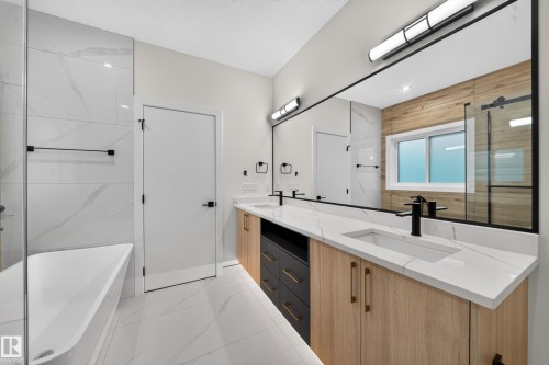 Freestanding tub with a glass shower enclosure, dual vanity with undermount sinks, and a full-width mirror - 13024 186 Avene Nw, Edmonton, AB 