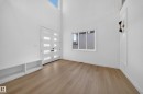 Double entry doors with frosted glass panels, wood-finish flooring, built-in storage bench, and an upper transom window - 13024 186 Avene Nw, Edmonton, AB 
