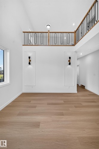 Wood-finish flooring, high ceilings, and a second-level open railing with black spindles - 13024 186 Avene Nw, Edmonton, AB 