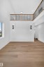 Wood-finish flooring, high ceilings, and a second-level open railing with black spindles - 13024 186 Avene Nw, Edmonton, AB 