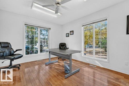Room featuring wood-finish flooring, white walls, and two large multi-pane windows - Edmonton, AB 