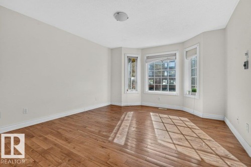 Hardwood flooring, bay window, white baseboards, white walls, and a ceiling light fixture - Edmonton, AB 
