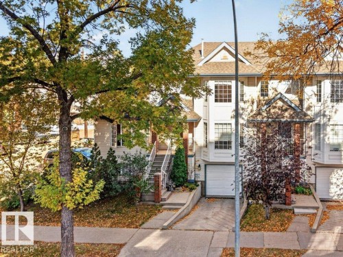 Three-story townhouse with light-colored siding, a pitched roof, and a single-car garage - Edmonton, AB 