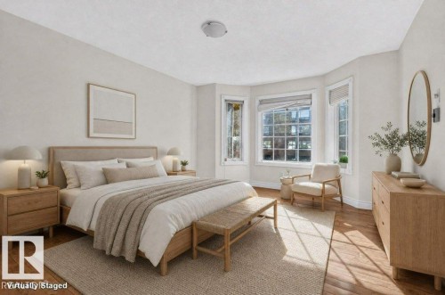 Light-filled room featuring wood-finish flooring, a bay window with multiple panes, and neutral wall tones - Edmonton, AB 