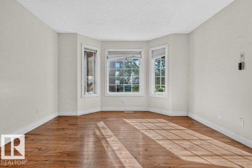 Bay window configuration with multiple large windows, wood-finish flooring, and crisp white trim - Edmonton, AB 