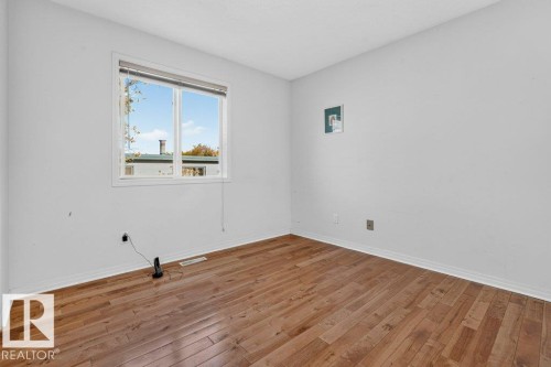 Wood-finish flooring, white painted walls, and a window with blinds - Edmonton, AB 