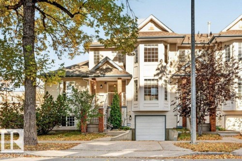 Siding exterior with a covered front entry, attached garage, bay windows, and mature trees - Edmonton, AB 