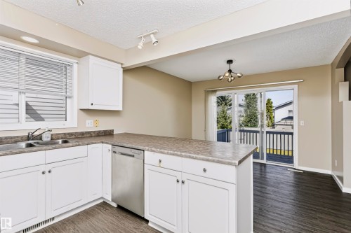 Kitchen featuring white cabinetry, stainless steel dishwasher, and a durable countertop - 4112 37A Avenue Nw, Edmonton, AB 