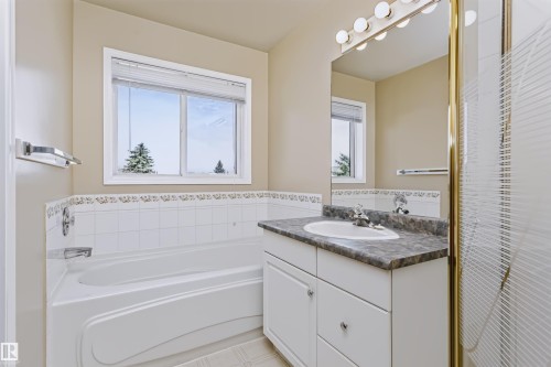 Integrated bathtub and shower combination with white tile surround - 4112 37A Avenue Nw, Edmonton, AB 