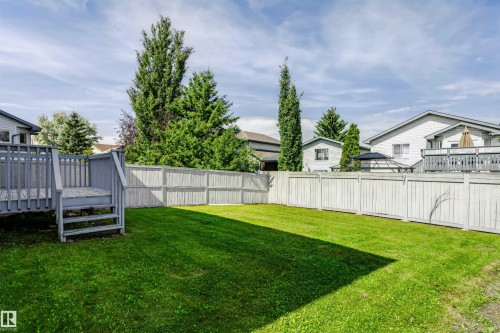 Expansive green lawn, privacy fencing, and a multi-level deck with railings - 4112 37A Avenue Nw, Edmonton, AB 