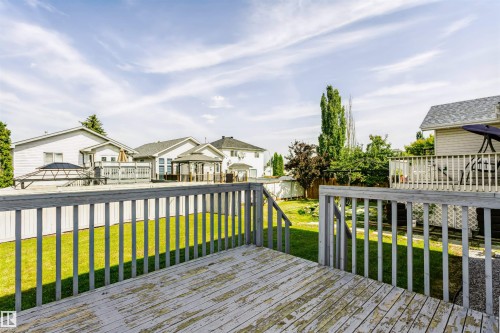 Expansive wooden deck with railing overlooking a green lawn - 4112 37A Avenue Nw, Edmonton, AB 