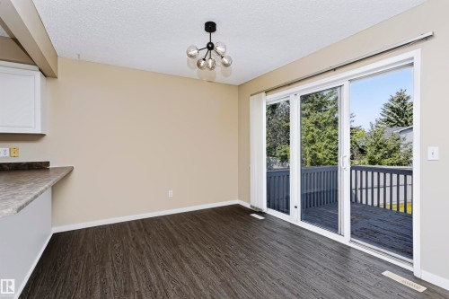 Dark wood-finish flooring with a contemporary chandelier - 4112 37A Avenue Nw, Edmonton, AB 
