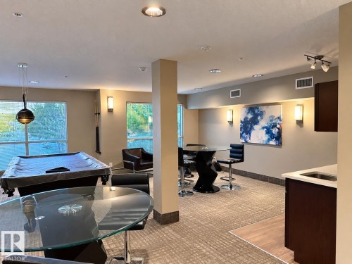 Recessed ceiling lighting, multiple large windows, and a built-in wet bar with a stainless steel sink - #116 4008 Savaryn Dr Sw Sw, Edmonton, AB 