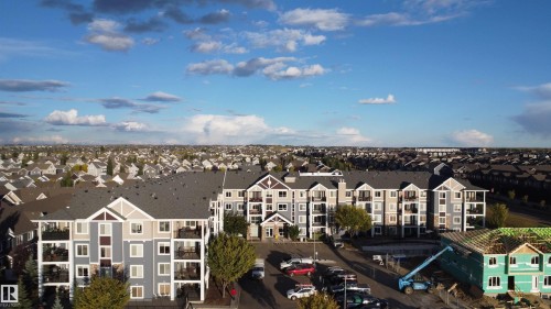 Multi-story building featuring multiple private balconies, varied exterior siding, and gabled rooflines, situated in an established residential area - #116 4008 Savaryn Dr Sw Sw, Edmonton, AB 
