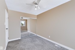 Wall-to-wall carpeting, mirrored sliding closet doors, ceiling fan with integrated lighting, and a white paneled door - 
