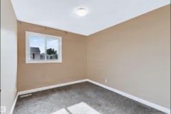 Neutral wall color, white trim, white ceiling, flush-mount ceiling light, and window with white frame - 