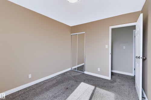 Wall-to-wall carpeting, neutral wall color, white ceiling, white trim, and a white interior door - 155 Primrose Gardens Gardens Nw, Edmonton, AB 