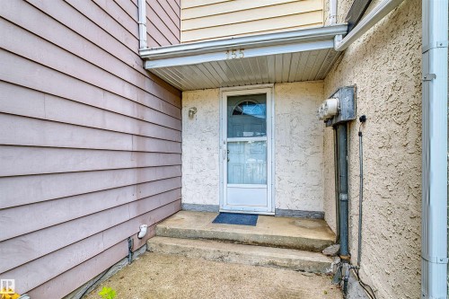 Entryway featuring a concrete stoop, stucco exterior, and horizontal siding - 155 Primrose Gardens Gardens Nw, Edmonton, AB 