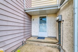 Entryway featuring a concrete stoop, stucco exterior, and horizontal siding - 