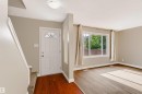 Entryway featuring a white paneled door with decorative glass, wood-finish flooring, and a flush mount ceiling light - 155 Primrose Gardens Gardens Nw, Edmonton, AB 