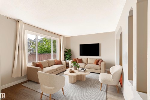 Spacious living area featuring a large window, wood-finish flooring, and arched wall openings - 155 Primrose Gardens Gardens Nw, Edmonton, AB 