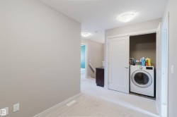 Upper-level laundry closet featuring a front-loading appliance and bi-fold door - 