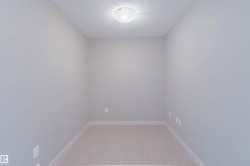Neutral-toned room featuring a flush-mount ceiling light fixture, light gray wall paint, white baseboards, and soft carpet flooring - 