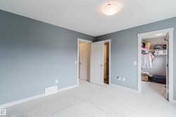 Bedroom featuring light gray walls, white trim, and light-colored carpet flooring - 