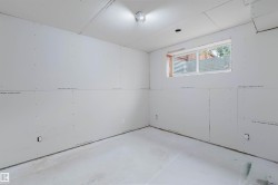 Unfinished room featuring drywall-installed walls and ceiling, a single window, and concrete flooring - 