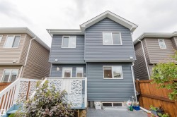 Multi-level rear exterior featuring blue horizontal siding and white trim - 