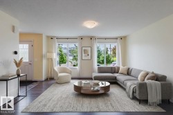 Spacious living area featuring wood-finish flooring, abundant natural light from multiple windows, and a recessed ceiling light fixture - 