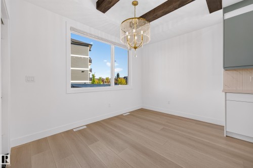 Wood-finish flooring, exposed ceiling beams, and a window with white trim - 11010 174A Avenue Nw, Edmonton, AB 