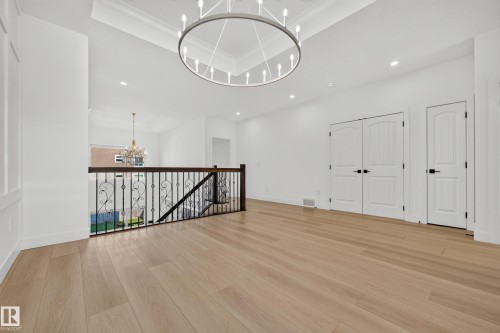 Wood-finish flooring, white walls, coffered ceiling, recessed lighting, and ornate metal railing - 11010 174A Avenue Nw, Edmonton, AB 