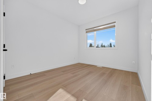 Light wood-finish flooring, white walls, and a recessed ceiling light - 11010 174A Avenue Nw, Edmonton, AB 