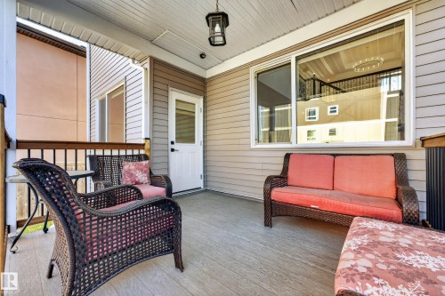 Covered outdoor patio with composite decking, white ceiling, and a black exterior light fixture - 11010 174A Avenue Nw, Edmonton, AB 