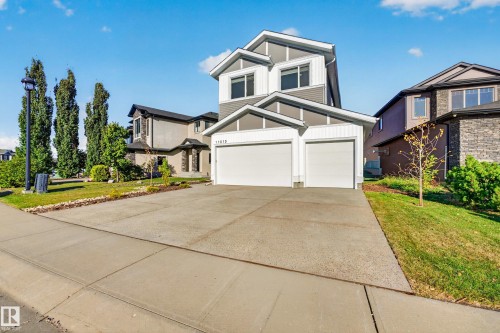 Contemporary home exterior featuring gray siding, white trim, a two-car garage, and a concrete driveway - 11010 174A Avenue Nw, Edmonton, AB 