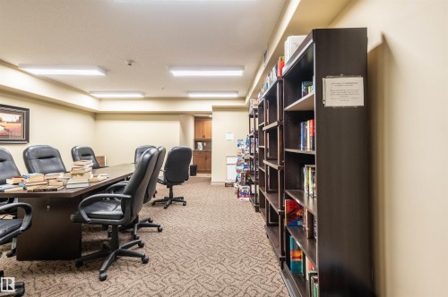 Conference room featuring a large table, multiple office chairs, built-in shelving, and recessed lighting - #230 45 Inglewood Dr, St. Albert, AB 