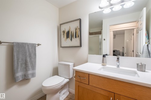 White vanity with an integrated sink, polished chrome faucet, and wood-finish cabinetry - #230 45 Inglewood Dr, St. Albert, AB 